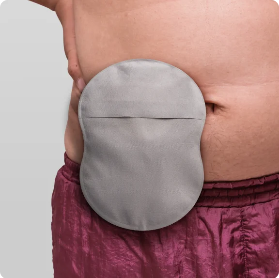 Bolsa de ostomía de color gris claro con defensa contra fugas y convexidad suave, que proporciona un sellado duradero en el vientre de un hombre.