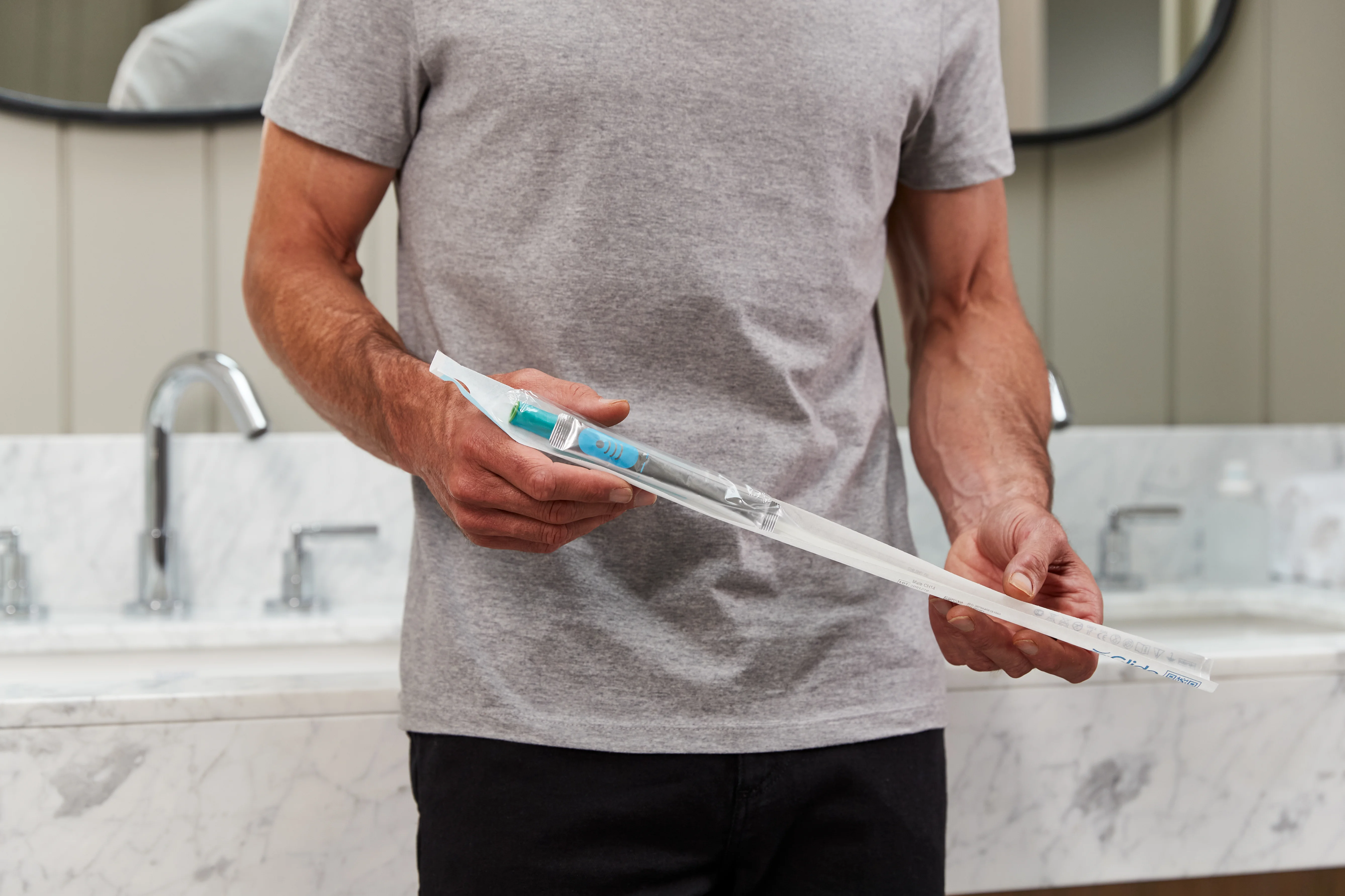 Man holding GentleCath Glide catheter