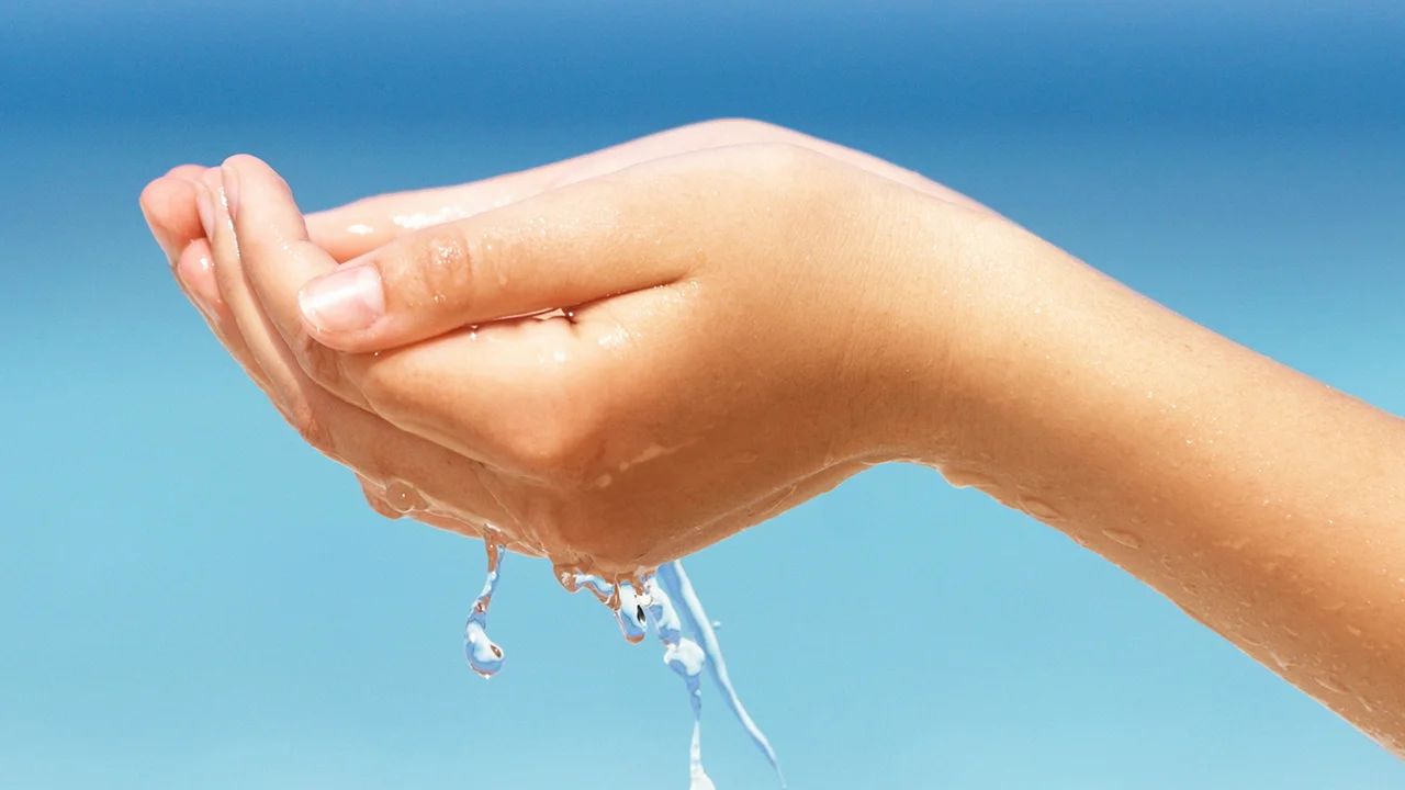 une main tenant un cordon d’eau